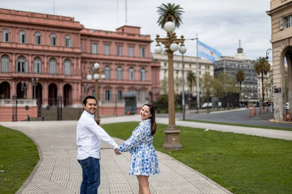 Sesión de fotos de pareja con la casa rosada de fondo