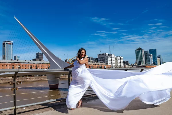 Sesión fotográfica con vestido volador blanco con el puente de la mujer de fondo